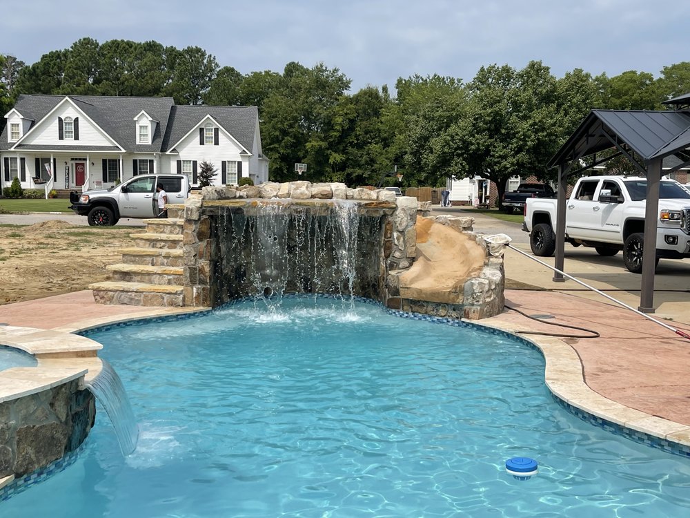 Freeform pool with rock waterfall, slide, and stone steps